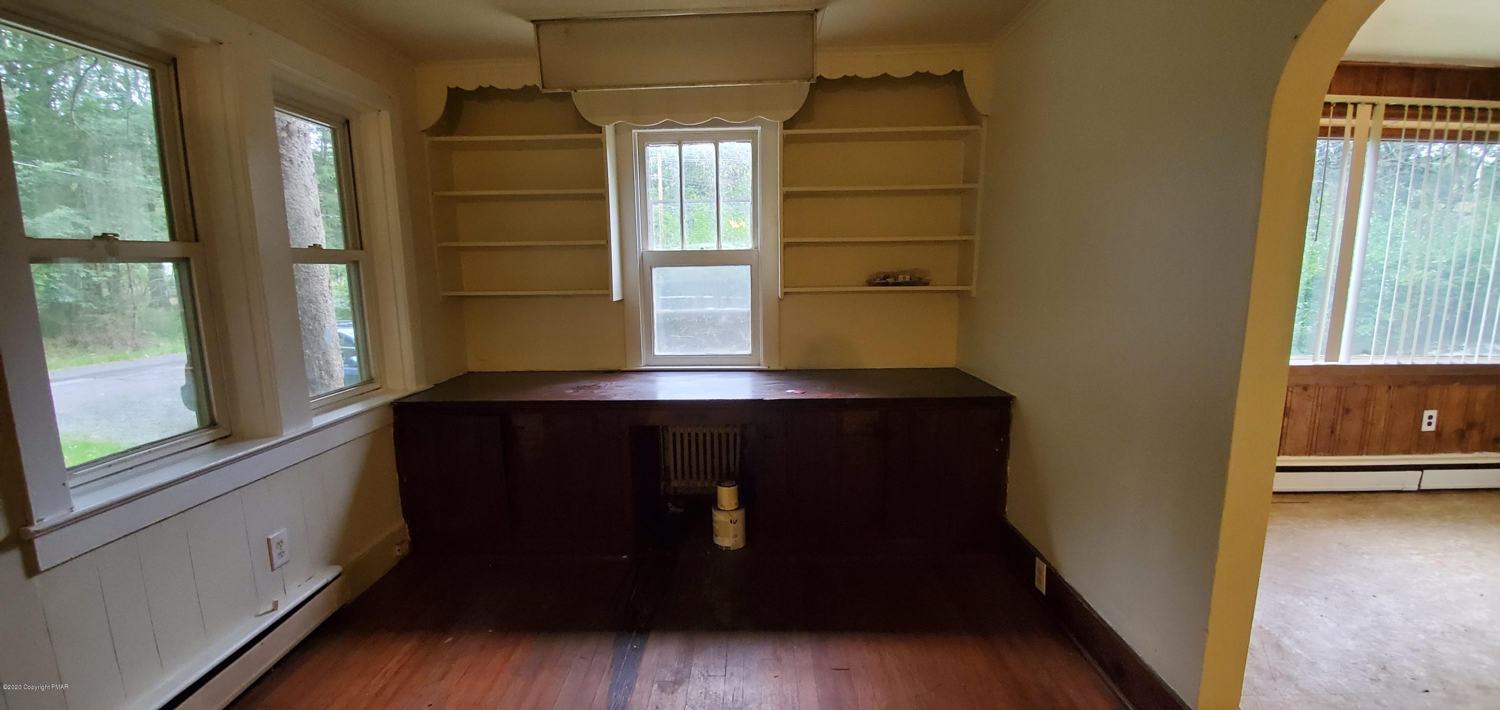 4132 Norton Pryor Road Pocono Summit, PA 18346 - Photo 23 of 36 a living room with a wooden floor and a large window