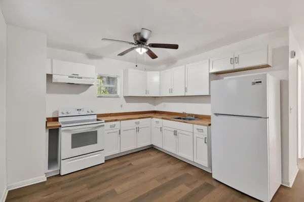 a kitchen with stainless steel appliances white cabinets and a refrigerator