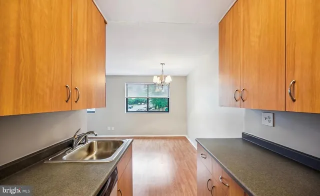 a view of a kitchen with wooden floor and a refrigerator