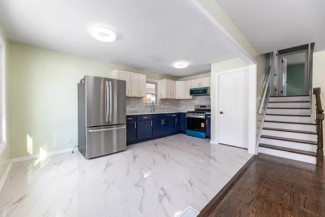 a kitchen with refrigerator and cabinets
