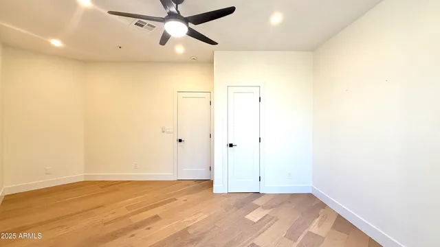 an empty room with a window and a chandelier fan