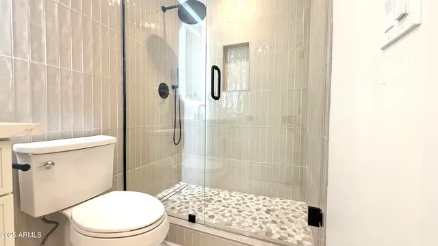 a bathroom with a sink a toilet a mirror and shower