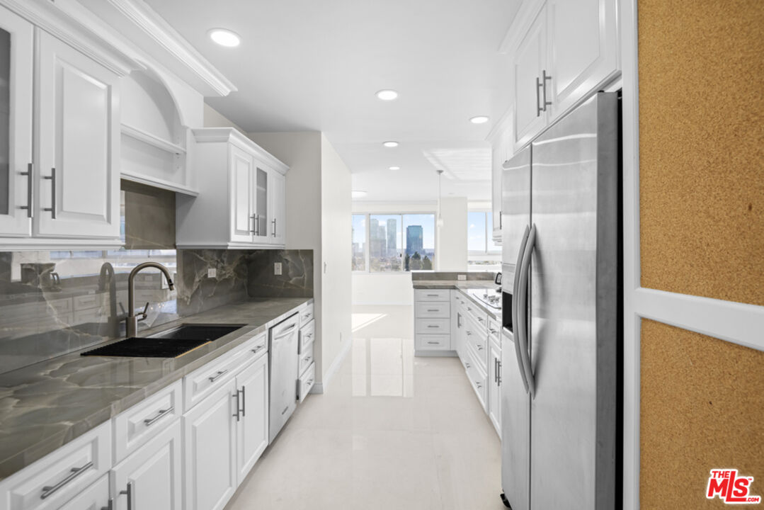 865 Comstock Avenue, Unit 10D/E Los Angeles, CA 90024 - Photo 14 of 49 a kitchen with stainless steel appliances granite countertop a refrigerator a sink and white cabinets