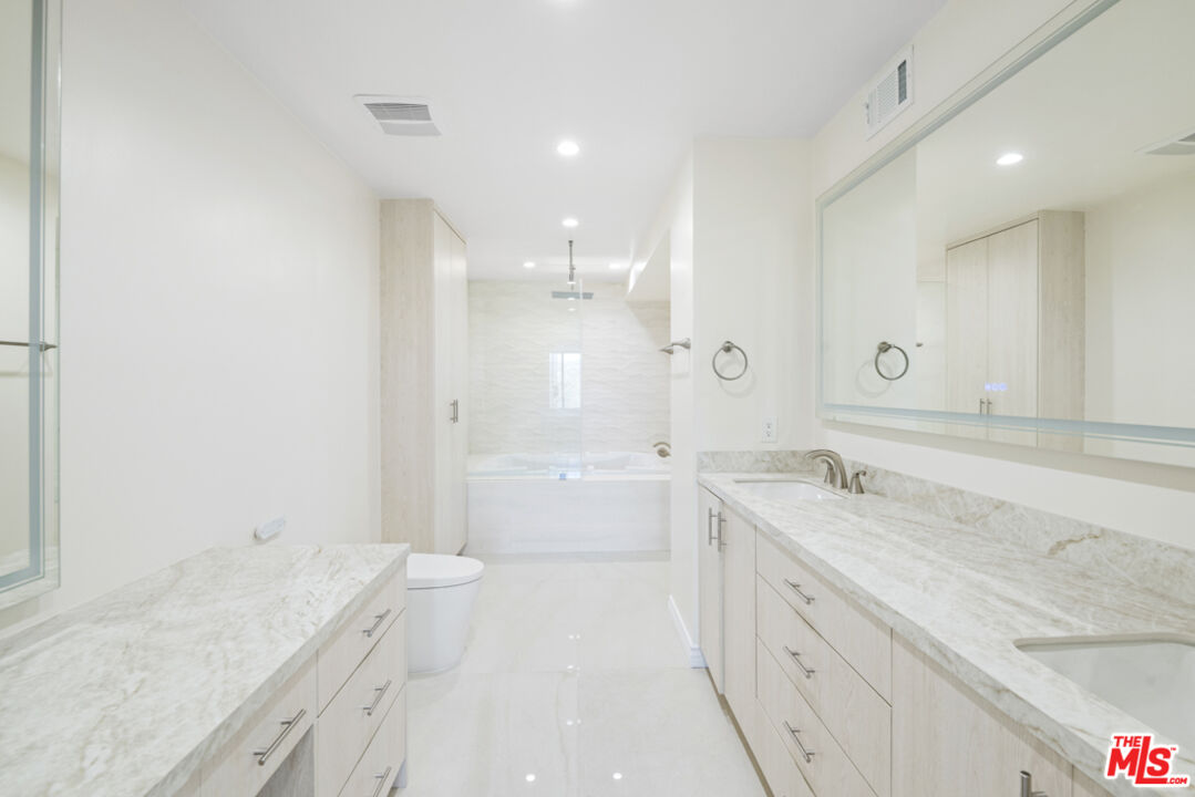 865 Comstock Avenue, Unit 10D/E Los Angeles, CA 90024 - Photo 26 of 49 a spacious bathroom with a granite countertop sink mirror and a bath tub