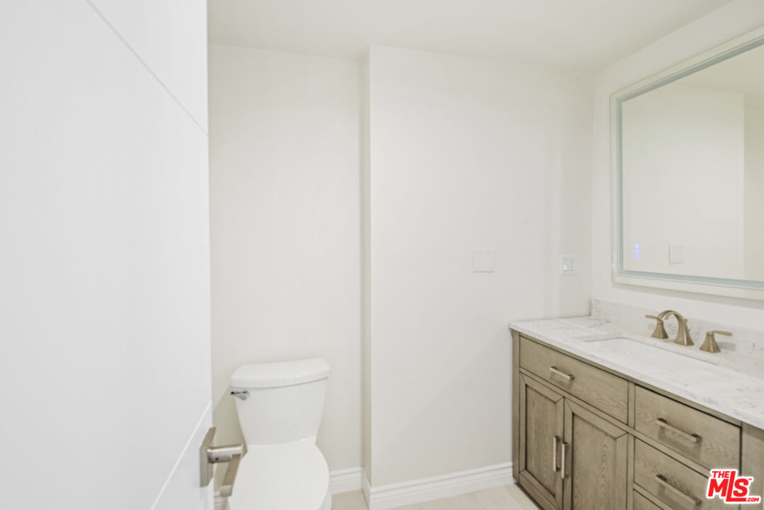 865 Comstock Avenue, Unit 10D/E Los Angeles, CA 90024 - Photo 29 of 49 a bathroom with a sink toilet and a mirror