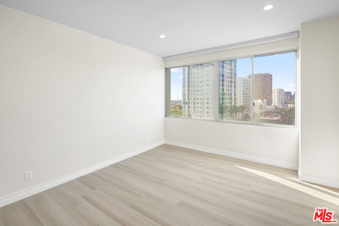 865 Comstock Avenue, Unit 10D/E Los Angeles, CA 90024 - Photo 33 of 49 an empty room with wooden floor and windows