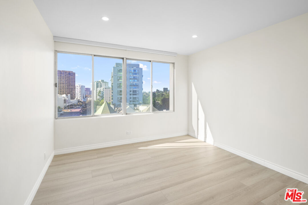 865 Comstock Avenue, Unit 10D/E Los Angeles, CA 90024 - Photo 35 of 49 an empty room with wooden floor and windows