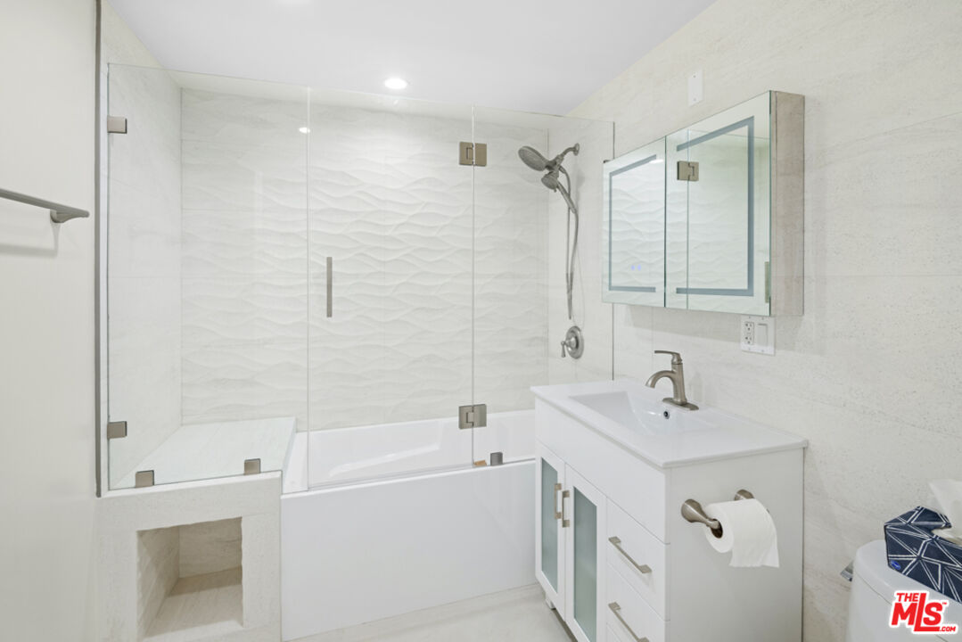 865 Comstock Avenue, Unit 10D/E Los Angeles, CA 90024 - Photo 37 of 49 a bathroom with a bathtub a sink a vanity and a shower