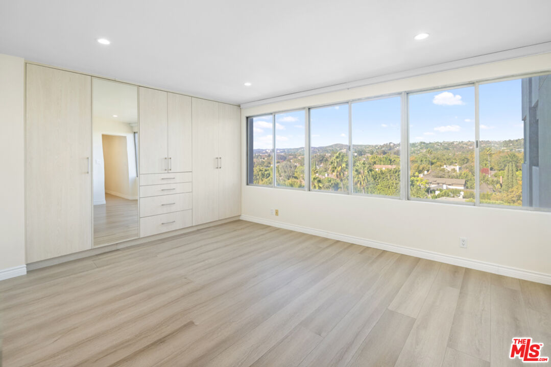 865 Comstock Avenue, Unit 10D/E Los Angeles, CA 90024 - Photo 38 of 49 an empty room with wooden floor and windows