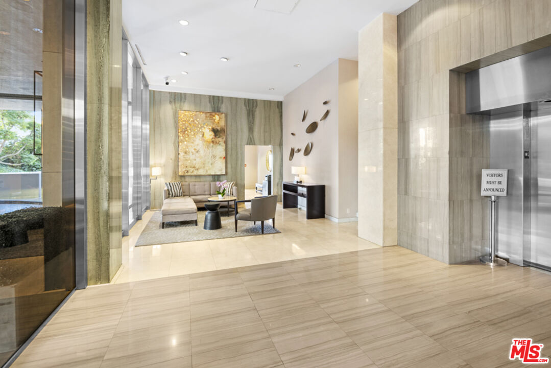 865 Comstock Avenue, Unit 10D/E Los Angeles, CA 90024 - Photo 4 of 49 a large living room with a large window and a wooden floor