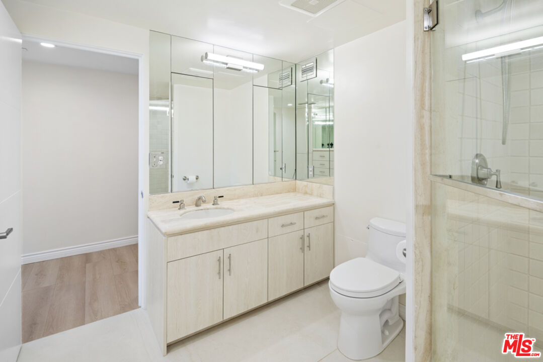 865 Comstock Avenue, Unit 10D/E Los Angeles, CA 90024 - Photo 42 of 49 a bathroom with a toilet a sink a mirror a shower a vanity and window
