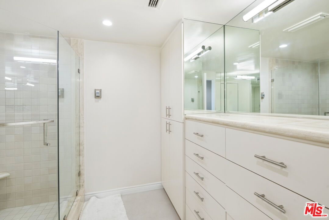 865 Comstock Avenue, Unit 10D/E Los Angeles, CA 90024 - Photo 44 of 49 a bathroom with a shower sink and mirror