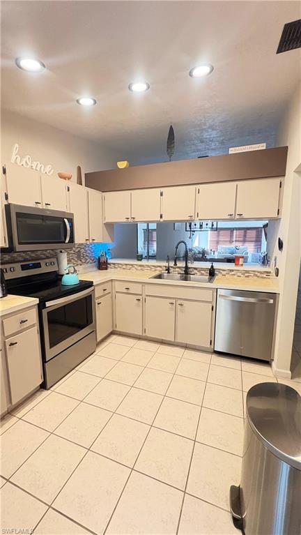 4120 Looking Glass Lane, Unit 3708 Naples, FL 34112 - Photo 12 of 25 Kitchen featuring stainless steel appliances, light countertops, light tile patterned floors, white cabinetry, and recessed lighting