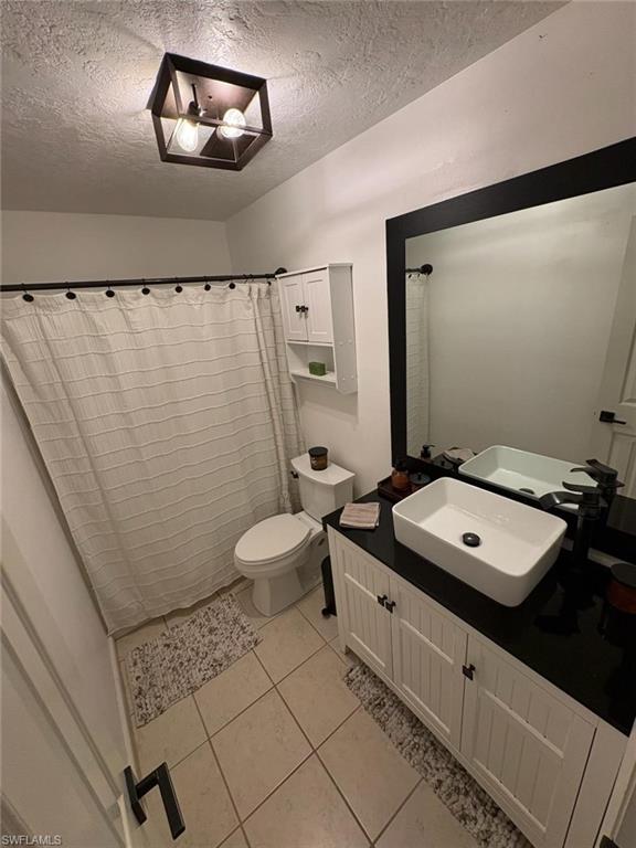 4120 Looking Glass Lane, Unit 3708 Naples, FL 34112 - Photo 21 of 25 Full bath with vanity, a shower, a textured ceiling, and light tile patterned floors