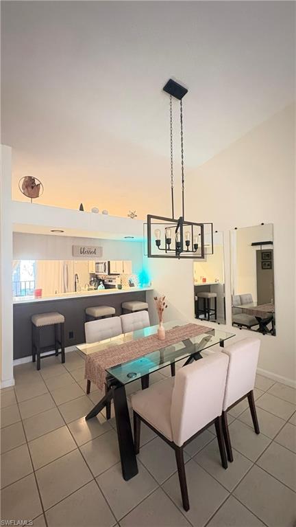 4120 Looking Glass Lane, Unit 3708 Naples, FL 34112 - Photo 8 of 25 Dining space featuring a chandelier, high vaulted ceiling, and light tile patterned floors