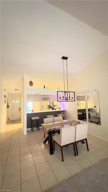 4120 Looking Glass Lane, Unit 3708 Naples, FL 34112 - Photo 9 of 25 Dining room with light tile patterned floors, high vaulted ceiling, and a chandelier