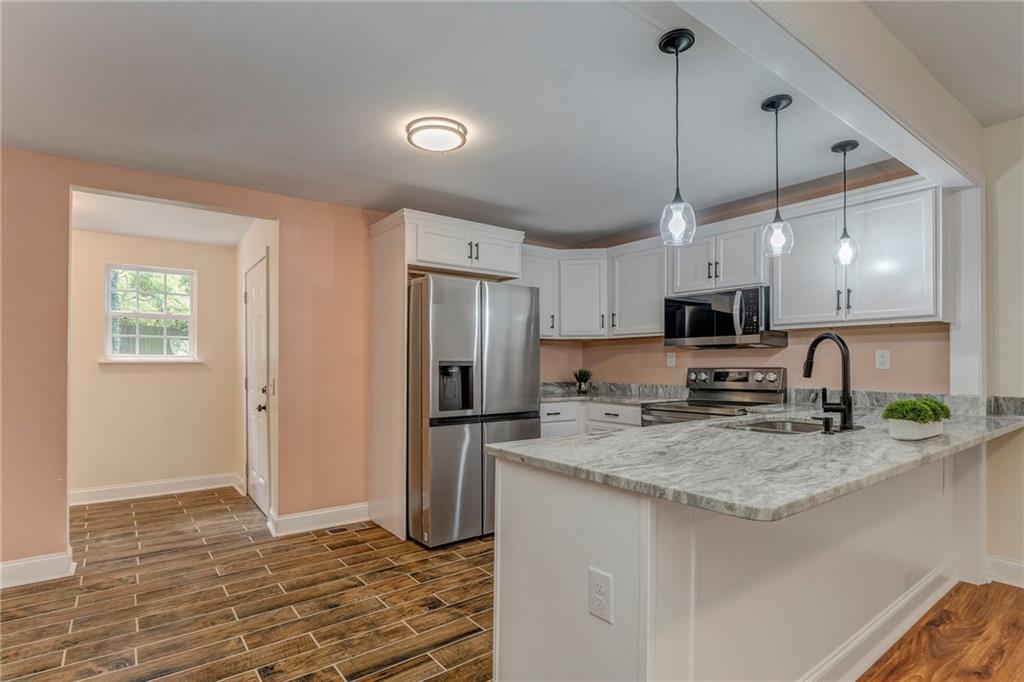 310 Kingston Avenue Northeast Rome, GA 30161 - Photo 26 of 45 a kitchen with stainless steel appliances granite countertop a sink a stove a refrigerator a center island and cabinets