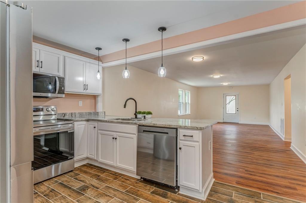 310 Kingston Avenue Northeast Rome, GA 30161 - Photo 28 of 45 a kitchen with stainless steel appliances granite countertop a sink and stove top oven
