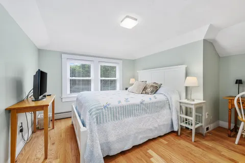 a bedroom with a large bed and a wooden floor