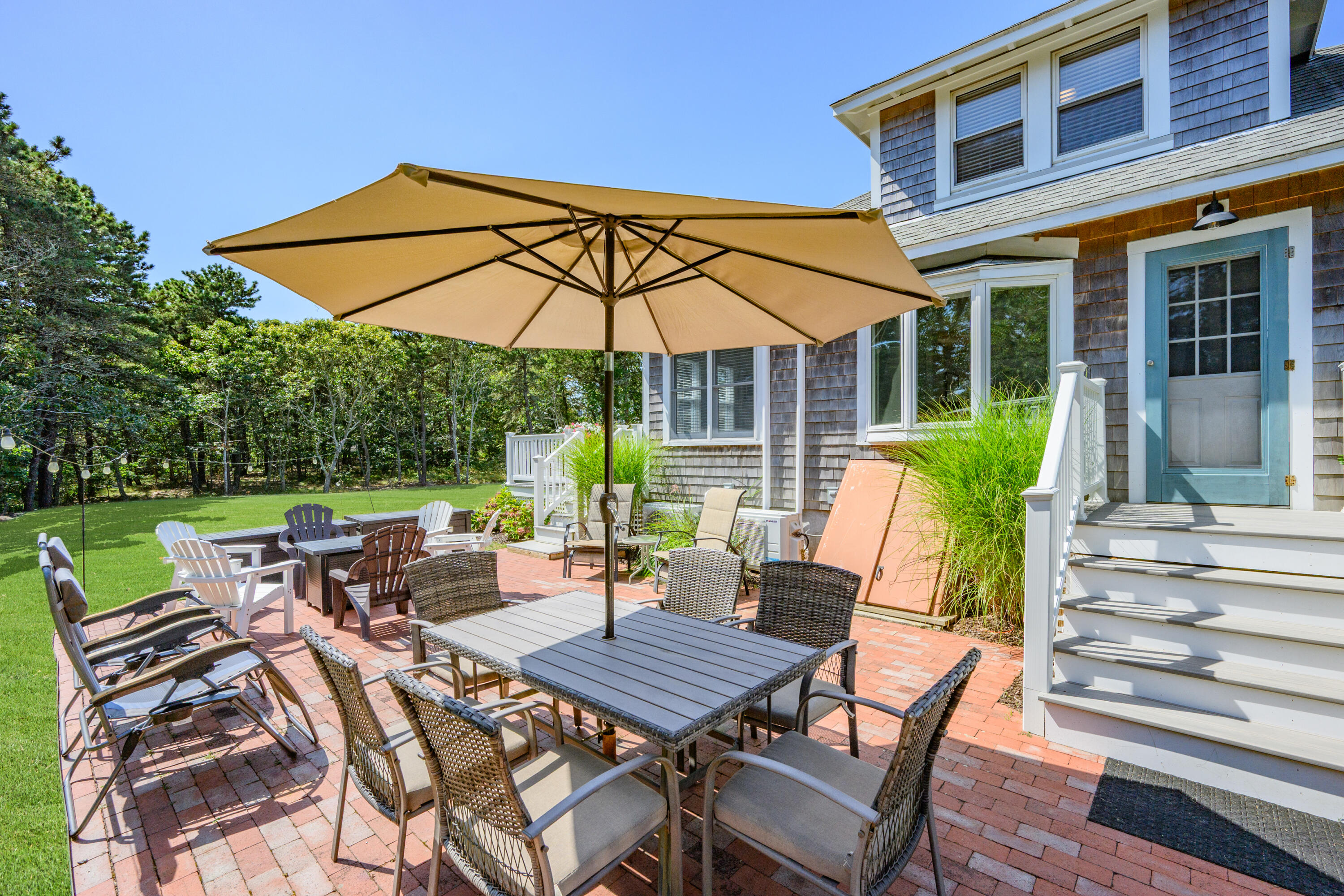 79 Forest Beach Road South Chatham, MA 02659 - Photo 39 of 60 a view of a patio with a table and chairs under an umbrella