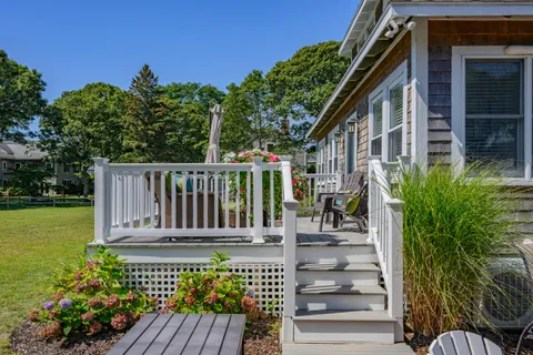 a view of a house with a big yard plants and large trees