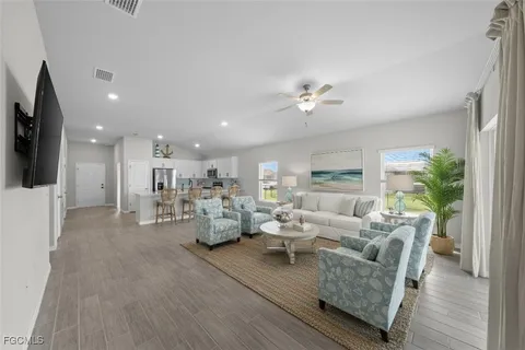 a living room with furniture flat screen tv and wooden floor