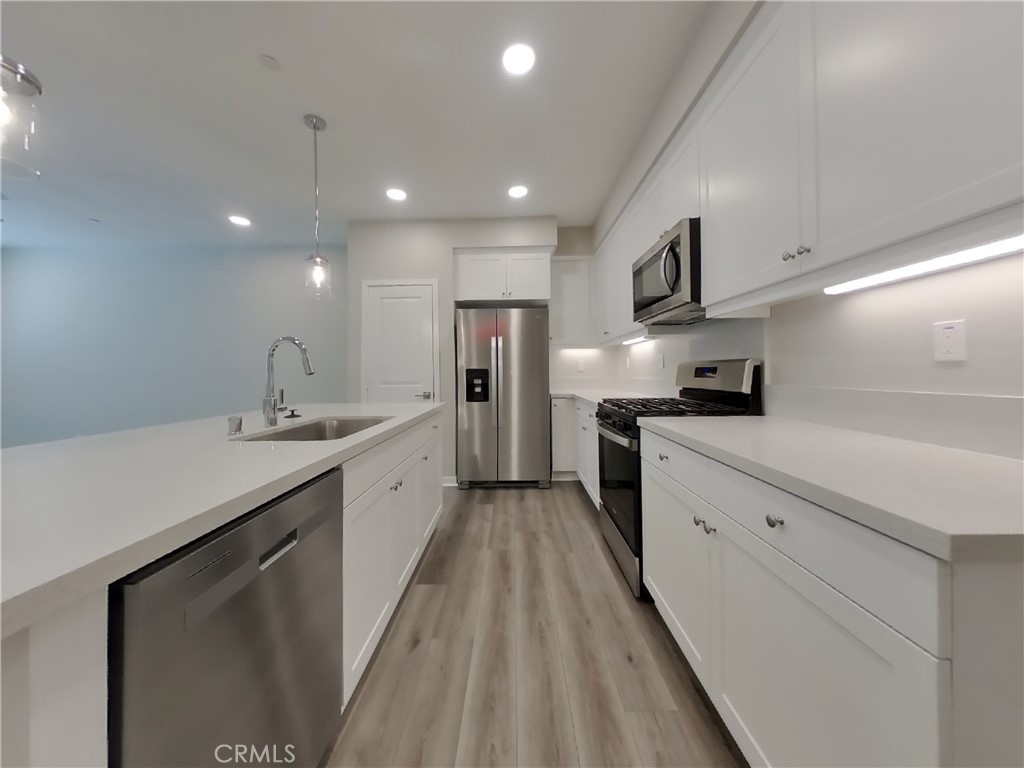 24967 Padre Court Wildomar, CA 92595 - Photo 4 of 30 a large kitchen with a large counter top a sink stainless steel appliances and cabinets