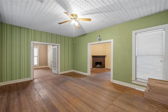 an empty room with wooden floor and a fireplace