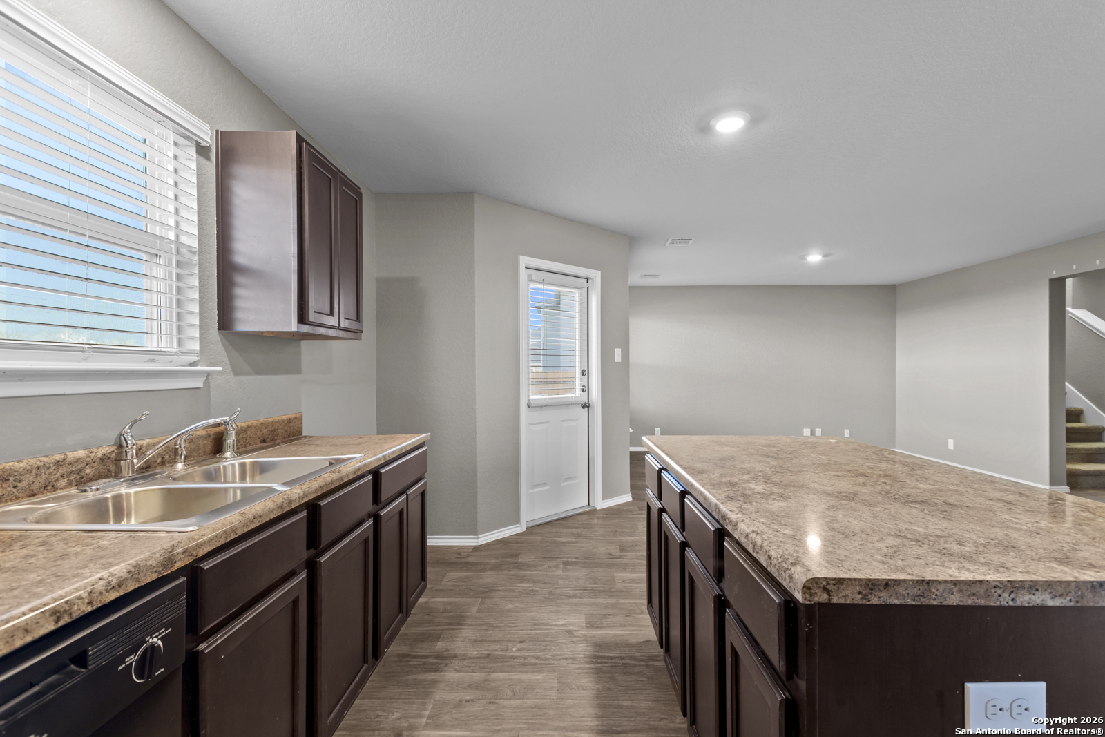 4106 Winterfell Pass Converse, TX 78109 - Photo 12 of 31 a kitchen with granite countertop kitchen island a sink dishwasher a stove and a refrigerator