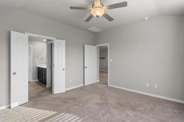 a view of an empty room with a chandelier fan