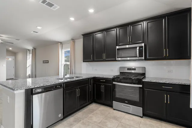 a kitchen with a sink stove and microwave
