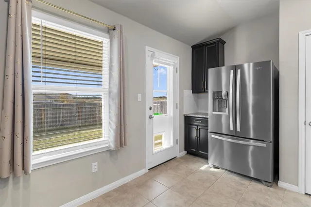 a kitchen with stainless steel appliances a refrigerator and a window