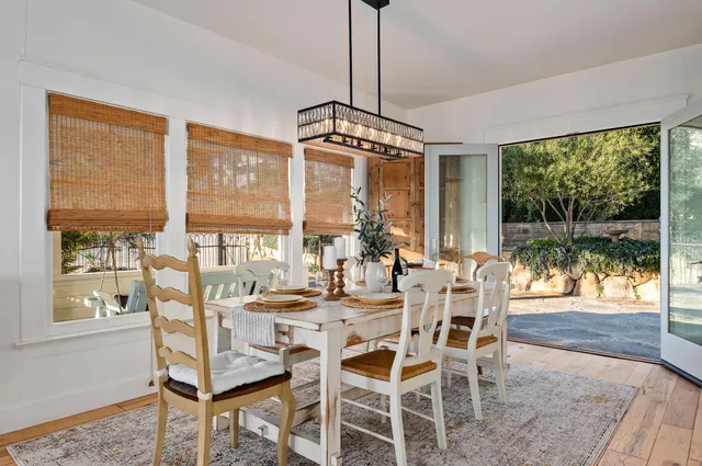 a view of a dining room with furniture large windows and wooden floor