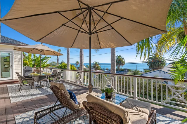 a view of a patio with couches under an umbrella