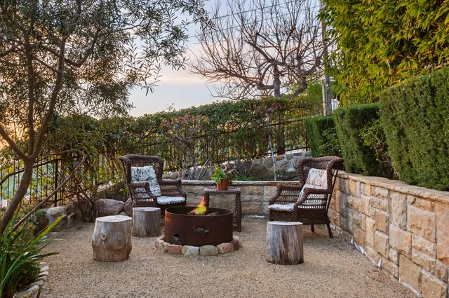 a view of a patio with table and chairs potted plants and large tree