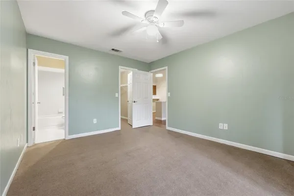 a view of an empty room and a ceiling fan window