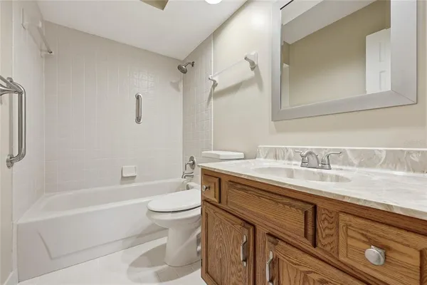 a bathroom with a granite countertop sink a toilet and a bathtub