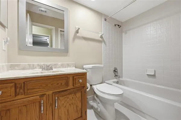 a bathroom with a granite countertop toilet sink and mirror