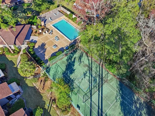 an aerial view of a house with a yard and large trees