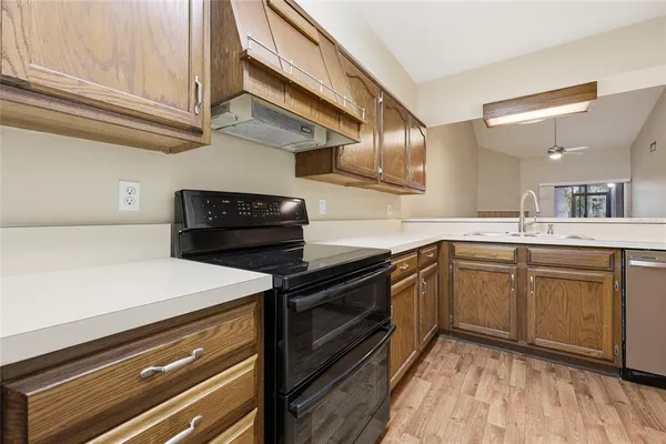 a kitchen with a stove cabinets and wooden floor