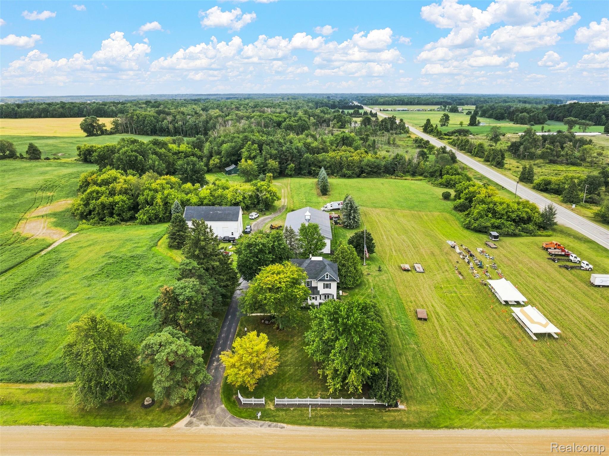 2971 Huron Line Road Cass City, MI 48726 - Photo 60 of 63 Expansive property featuring multiple buildings, lush green fields, mature trees, and a paved road