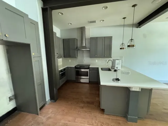 a kitchen with stainless steel appliances a sink stove and cabinets
