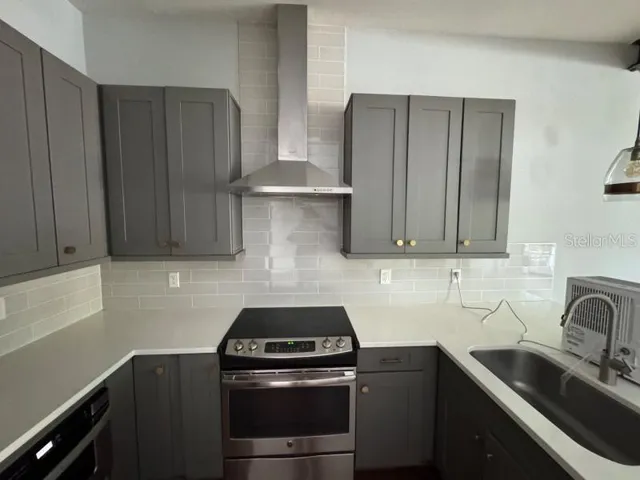 a kitchen with stainless steel appliances wooden cabinets and a stove top oven