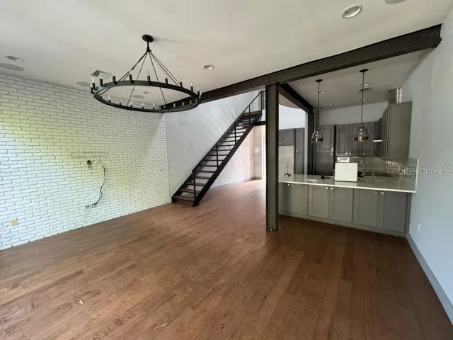 a view of a room with gym equipment and wooden floor