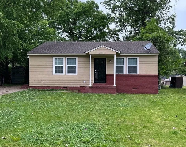 a front view of a house with yard and green space