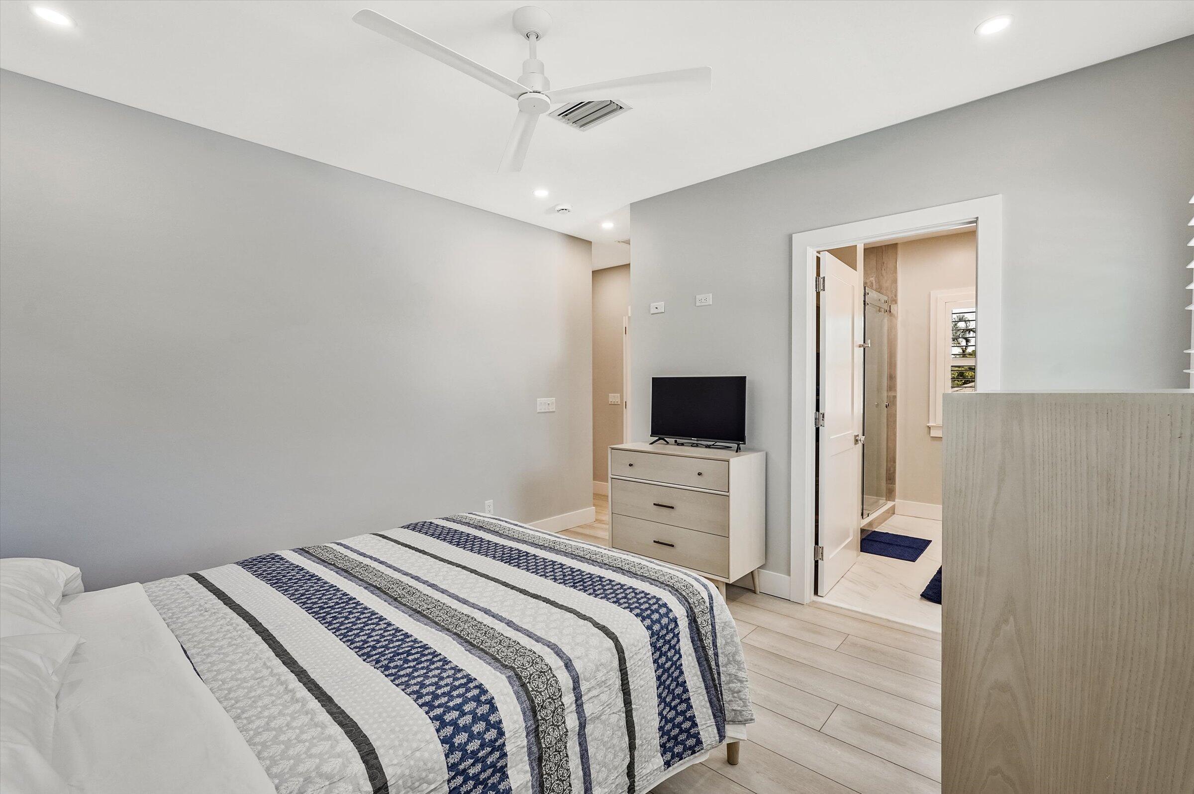 425 Hugh Street Jupiter, FL 33458 - Photo 29 of 41 a bedroom with a bed and a flat screen tv