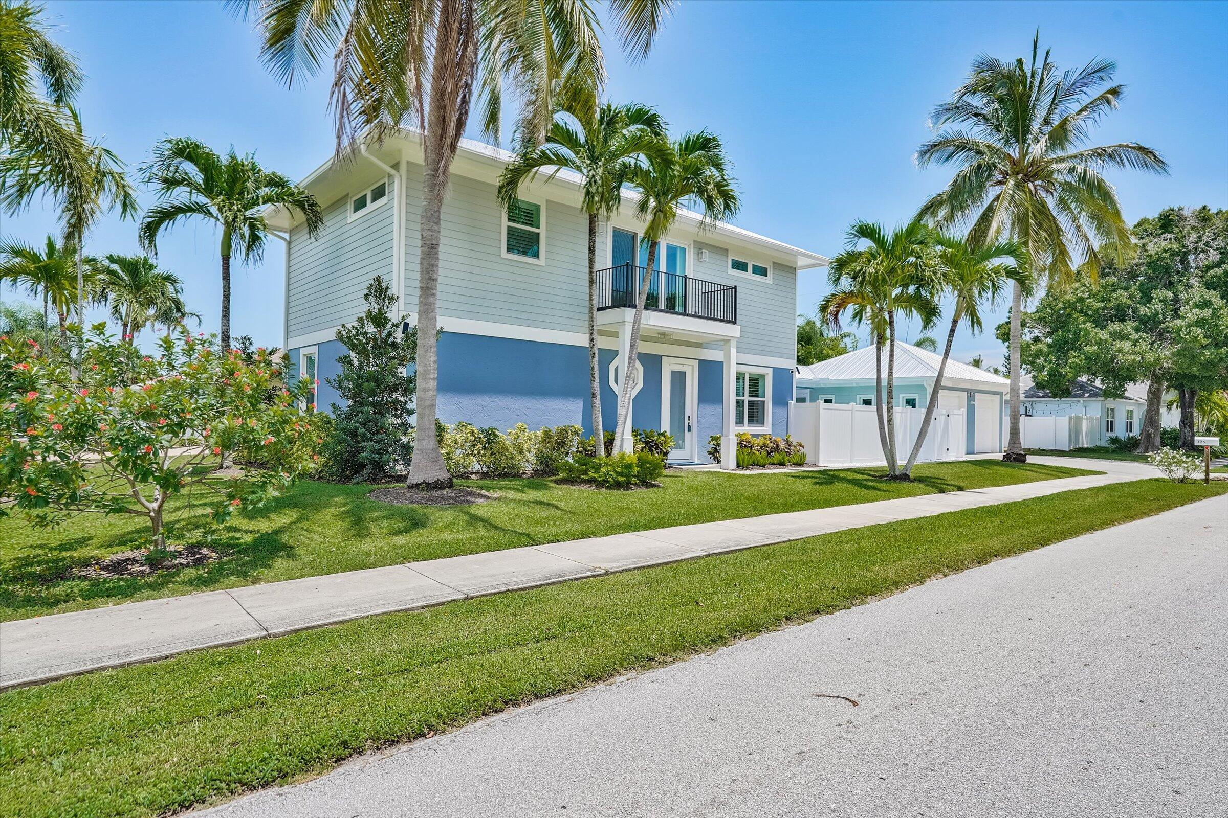 425 Hugh Street Jupiter, FL 33458 - Photo 3 of 41 a front view of a house with a garden and fountain