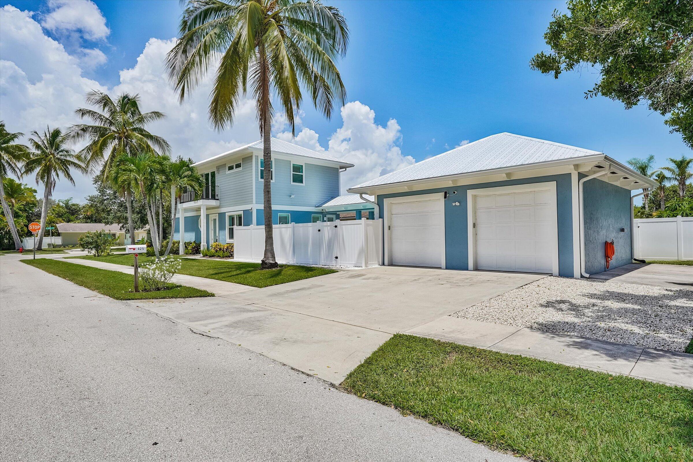 425 Hugh Street Jupiter, FL 33458 - Photo 4 of 41 a view of a house with a yard and palm trees