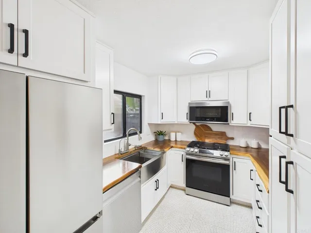 a kitchen with stainless steel appliances a stove microwave and refrigerator