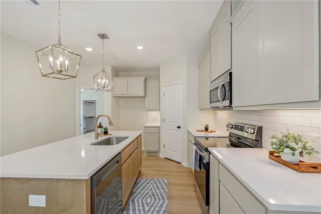 a kitchen that has a sink and a stove top oven